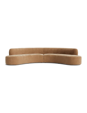 Cara Sectional Sofa in a curved camel shade features a modern, minimalist design composed of two sections. It offers a clean, smooth finish with low-profile backrests, perfect for contemporary living spaces. The backdrop is plain black.