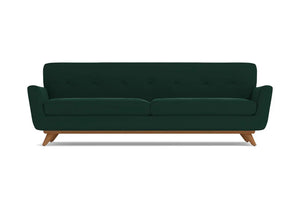 Introducing the Carson Sofa: a dark green, mid-century modern piece featuring a button-tufted backrest and wooden legs. This sofa boasts a sleek, minimalist design complemented by slightly flared armrests.