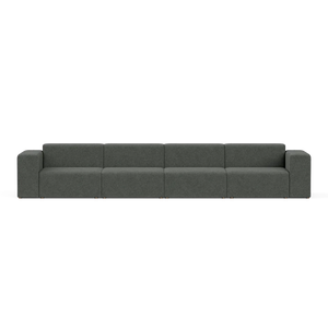 The Four-Seater Form Sectional is a long, modern sofa in dark gray featuring four evenly spaced sections and boxy armrests, set against a plain white background. Its minimalist design provides ample seating space.