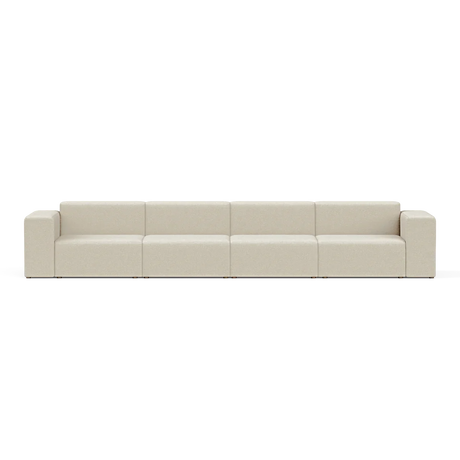 The Four-Seater Form Sectional is a long, beige modular sofa featuring four sections and square armrests. Set against a plain white background, it highlights its minimalist and contemporary design.