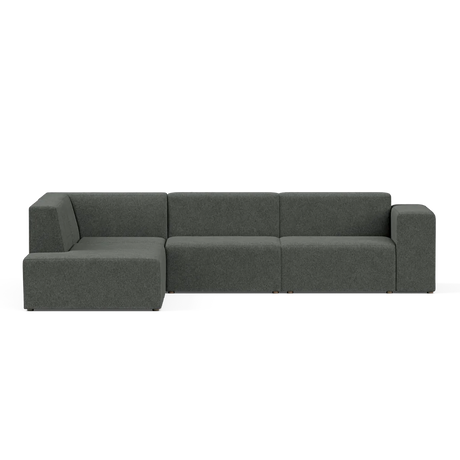The Four-Seater Form Sectional is a dark green modular sofa with a modern design, featuring three main seating sections and a left chaise lounge. Set against a plain black background, the sofa boasts clean lines and a minimalist aesthetic.