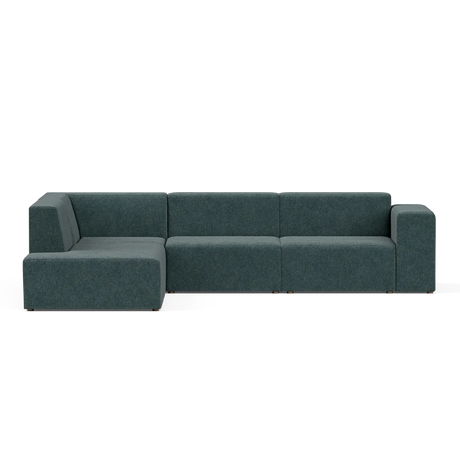 A contemporary Four-Seater Form Sectional in a dark green shade, characterized by its clean lines and low profile. It is arranged on a light-colored surface, consisting of three main sections and an extended chaise to the left, embodying a sleek and minimalist design.
