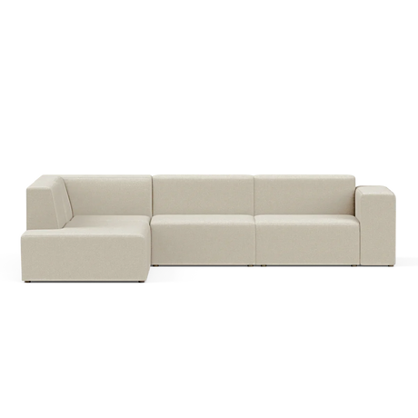 The Four-Seater Form Sectional is a modern, beige sofa featuring clean lines and a minimalist design. It includes a chaise lounge section on the left, all set against a plain, black background.
