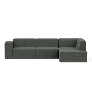 A contemporary Four-Seater Form Sectional in a dark green hue, showcasing clean lines and a minimalist aesthetic, placed against a plain black backdrop. The sectional includes three main sections, featuring an extended right-side chaise.