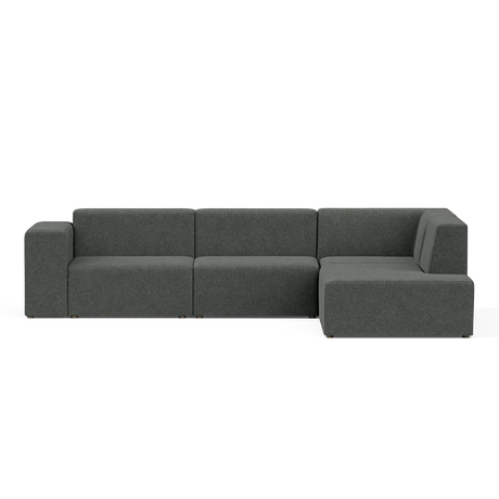 A contemporary Four-Seater Form Sectional in a dark green hue, showcasing clean lines and a minimalist aesthetic, placed against a plain black backdrop. The sectional includes three main sections, featuring an extended right-side chaise.