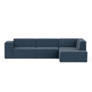 The Four-Seater Form Sectional is an L-shaped sofa in navy blue, featuring a minimalist design with flat backrests and armrests. Its spacious seating sits elegantly against a neutral background, making it perfect for modern living rooms.