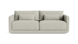 A modern, minimalist two-seater Eva 85" Sofa in beige features clean lines and comes with two matching rectangular cushions on each seat, enhancing its comfortable and stylish look against a black background.