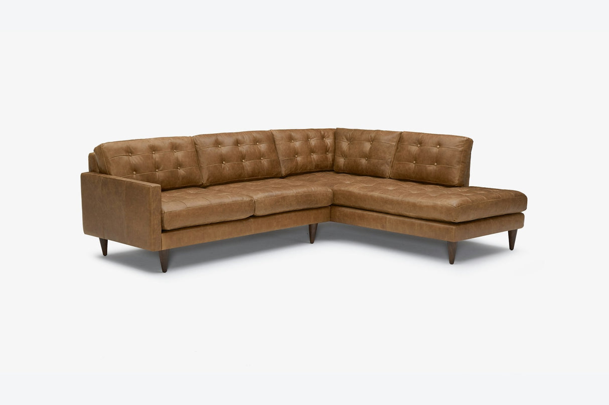 The Eliot Leather Sectional with Bumper, featuring brown leather upholstery, button-tufted cushions, and wooden legs, is showcased in an L-shape against a plain white background.