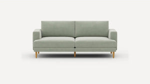 The Ember Mid-Century Modern 75" Sofa is showcased against a plain white background, highlighting its minimalist and contemporary design with a light green color, clean lines, and wooden legs. It includes two seat cushions and two back cushions for added comfort.