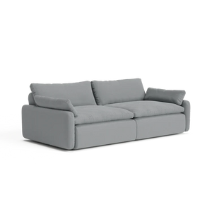 Introducing The Sink Down Sectional: a contemporary gray sofa with plush cushions and two large back pillows, showcasing a minimalist design. This sofa features wide armrests and a low-profile frame, all set against a white backdrop.