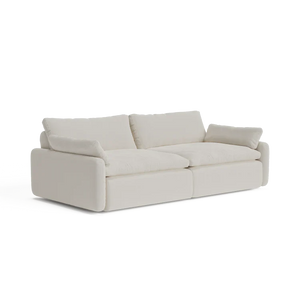 Introducing The Sink Down Sectional, a trendy white sofa with a sleek modern design. It showcases thick cushions and armrests, making it the ideal choice to bring a contemporary feel to any living room.
