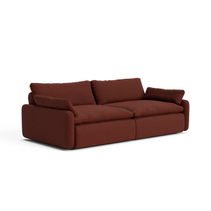 The Sink Down Sectional is a plush sofa in a deep red shade, featuring soft cushions and wide armrests. Its contemporary design and cozy, inviting appearance make it perfect for a modern living room.