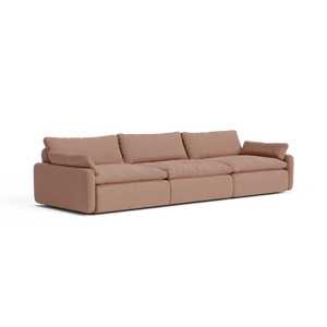 The Sink Down Sectional offers a modern design in beige, featuring three spacious seats with large, plush cushions and armrests on each end. Its simple, clean style makes it ideal for a contemporary living room setting.