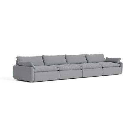 The Sink Down Sectional is a long, modern light gray sectional sofa that includes five large cushions. It boasts clean lines and a minimalist design, making it ideal for a contemporary living room against a plain white background.