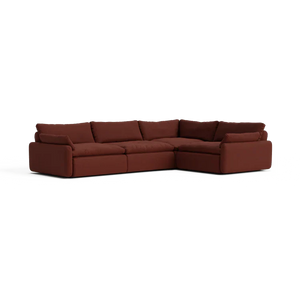The Sink Down Sectional is a large, L-shaped, brown sofa featuring plush cushions and a low backrest, all set against a white background. Its modern design includes deep seating for enhanced comfort.