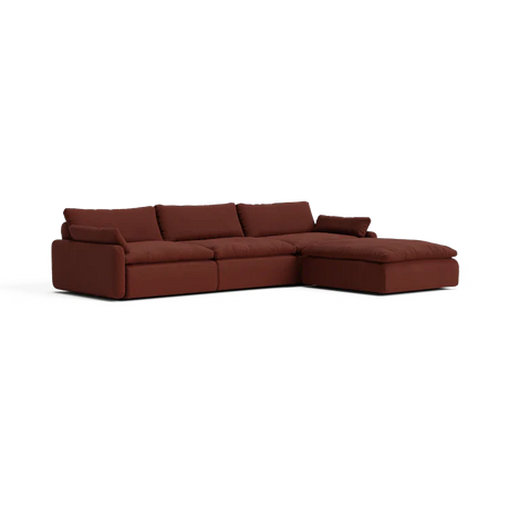 Introducing The Sink Down Sectional – a dark brown sofa featuring plush cushions and a modern design. With its right-side chaise extension, it’s perfect for lounging and relaxation.