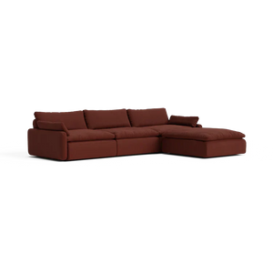 Introducing The Sink Down Sectional – a dark brown sofa featuring plush cushions and a modern design. With its right-side chaise extension, it’s perfect for lounging and relaxation.