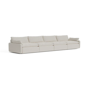 The Sink Down Sectional is a long, modern sectional sofa with a white fabric finish, featuring multiple cushions and a minimalist design, set against a plain background.