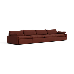 The Sink Down Sectional is a contemporary, extended sofa with a luxurious deep brown fabric finish. It consists of five interconnected seats, complete with plush backrests and armrests at both ends, showcased against a clean white backdrop.