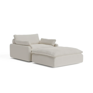 Introducing The Sink Down Sectional: an inviting, off-white chaise lounge featuring thick cushions and a contemporary design with an elevated headrest and armrest on one side, perfect for creating a plush seating area.