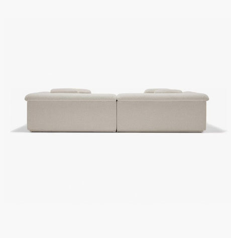 The image displays the Float Sofa, a minimalistic beige modular sofa set against a plain white background. It features two low-profile sections with flat cushions that highlight its modern and understated design.
