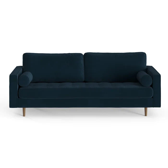 The Geo 84'' Upholstered Sofa is a modern three-seater in dark blue, designed with two back cushions and two cylindrical bolster pillows on each end. It showcases a minimalist style with wooden legs and is set against a white background.