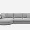 A modern, light gray sectional sofa with a round left chaise and four square back cushions. The sofa includes two smaller square pillows, set against a white background.