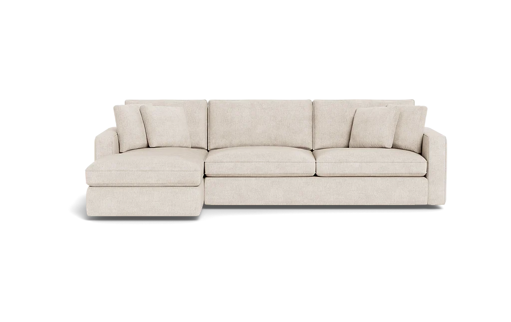 The James 3 Seat Left Chaise 92" Sectional is a beige sofa with an extended left-side chaise, three seat cushions, multiple back cushions, and is showcased against a black background. Its modern and minimalist design highlights clean lines.