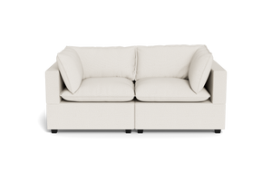 The Kova Pillow Cushion Sofa 86" is a modern, light beige two-seater with square armrests and plush cushions, shown from the front against a plain black background.