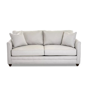 The Kodie 76.5" Upholstered Sleeper Sofa is a light gray piece featuring two seat cushions and matching back cushions, complemented by two square pillows on each side. It boasts a clean, modern design with slightly flared arms and rests on short dark wooden legs.