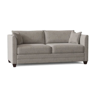 The Kodie 76.5" Upholstered Sleeper Sofa is a modern gray fabric piece featuring clean lines, two seat cushions, two back cushions, and two matching throw pillows, all set on dark wooden legs.