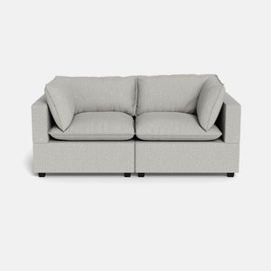 The Kova Pillow Cushion Sofa 86" is a modern, light grey two-seater with square arms and plush cushions, displayed against a plain white background.