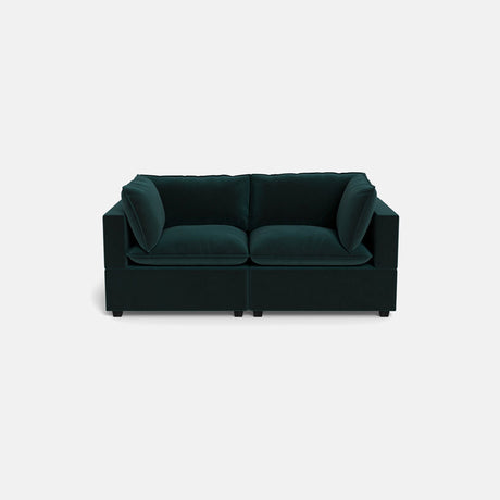 The Kova Pillow Cushion Sofa 86" is a modern dark green velvet sofa with two seat cushions and four back cushions, displayed against a plain light gray background.