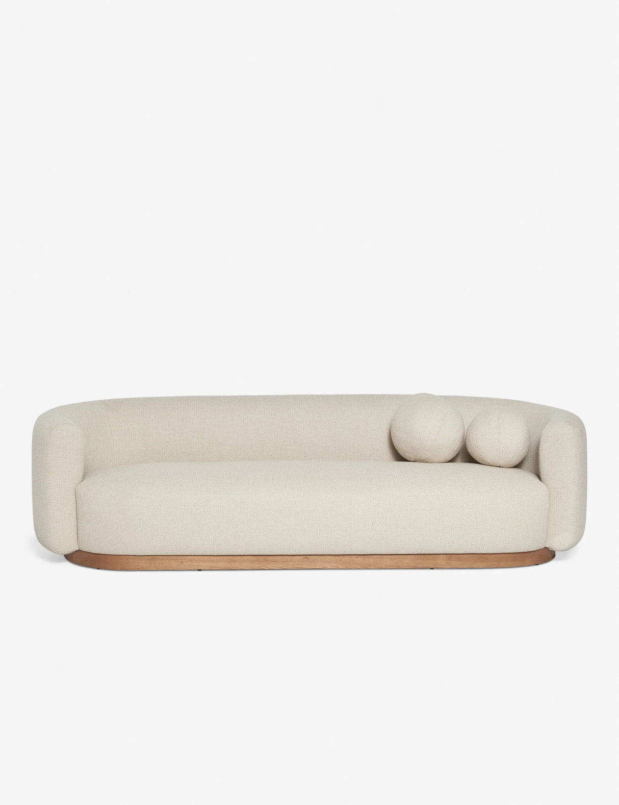 Introducing the Lowry Sofa: a contemporary cream-colored seating option with smoothly curved edges and a wooden base. It includes two coordinating round cushions on one side, all showcased against a clean white backdrop.