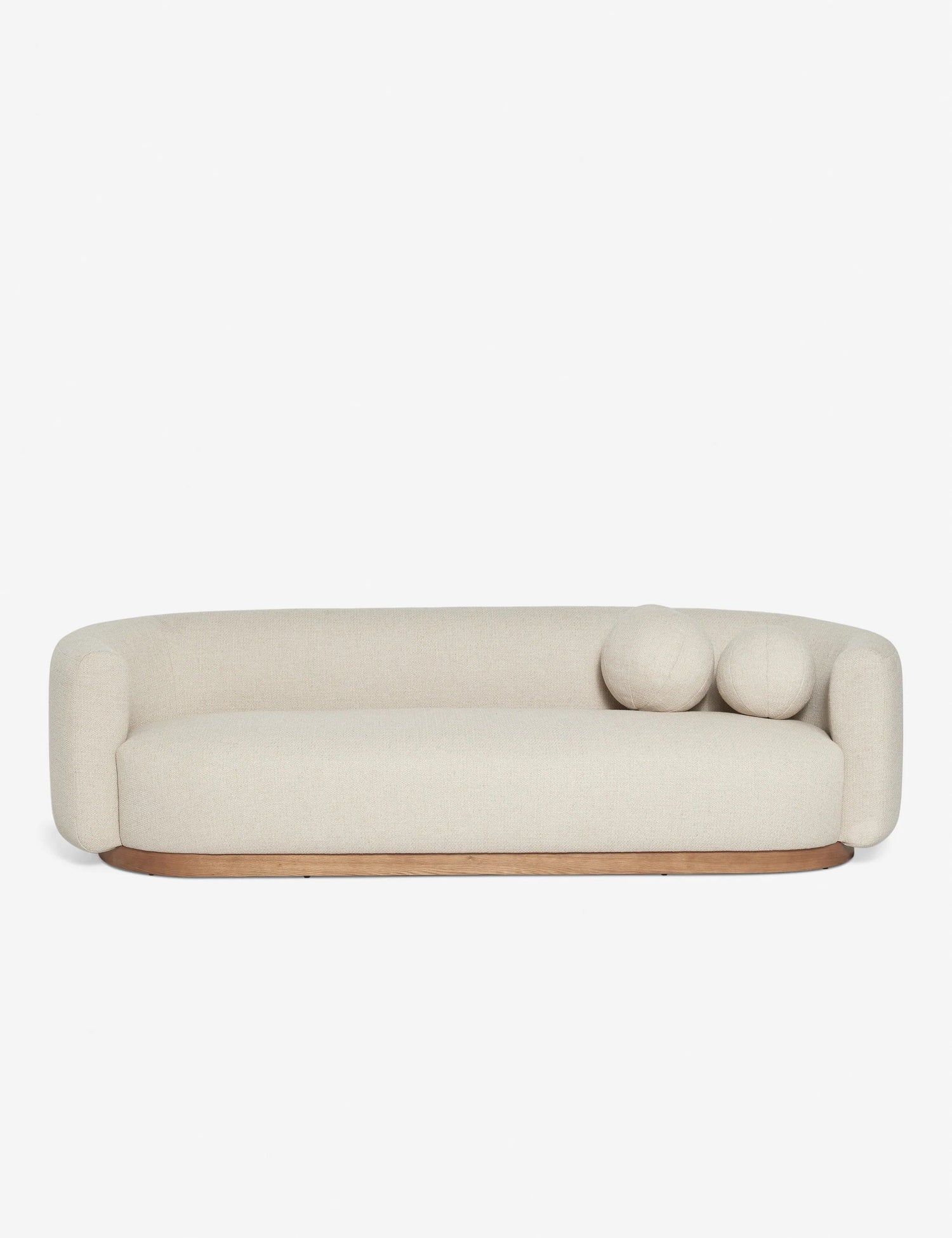 Introducing the Lowry Sofa: a contemporary cream-colored seating option with smoothly curved edges and a wooden base. It includes two coordinating round cushions on one side, all showcased against a clean white backdrop.