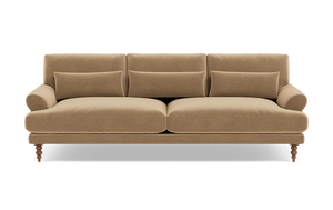 The Maxwell Custom Sofa is a beige, three-seater with plush cushions and rolled arms, supported by four wooden legs. It features three back cushions and a soft velvet-like texture, providing a cozy and elegant appearance against a plain background.