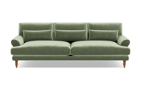 The Maxwell Custom Sofa, upholstered in green velvet, features three seat cushions and matching backrests. It comes with three rectangular pillows and has elegantly rounded armrests. The sofa is supported by four wooden legs, blending a classic touch with its modern design.