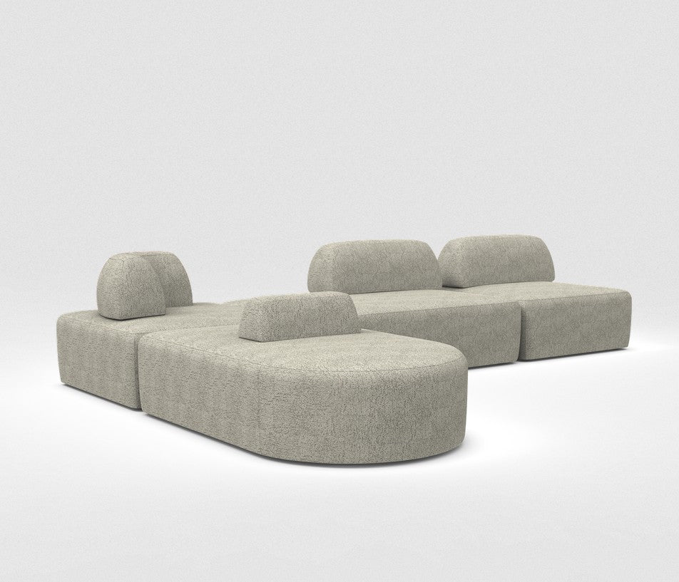 The Magna Preconfigured Sectional is a modular gray sofa set with three low backrests, featuring rounded and rectangular shapes. It has a soft, textured fabric and is set against a plain white background.