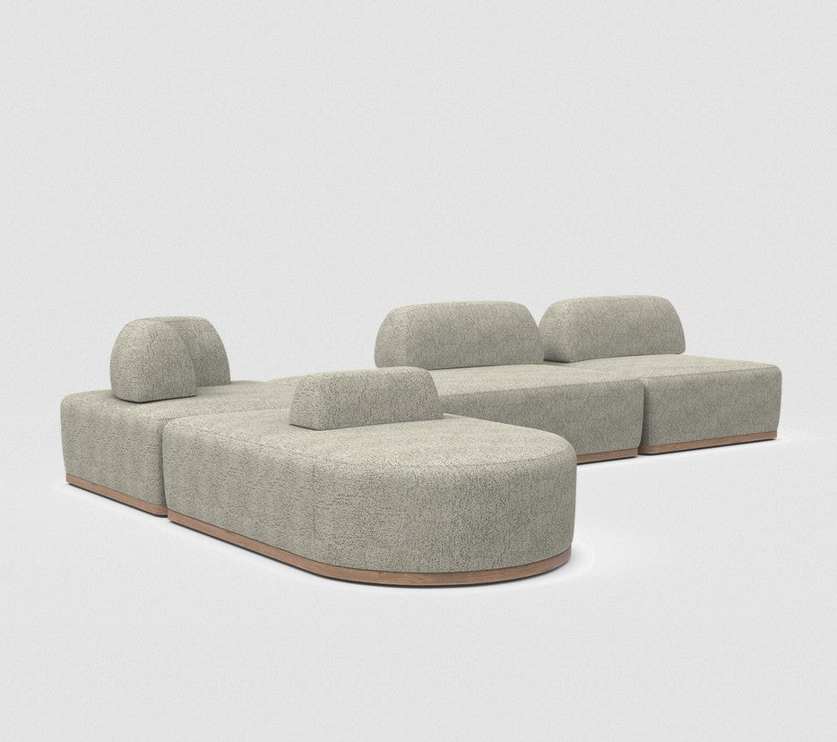 The Magna Preconfigured Sectional is a modular gray fabric sofa with rounded edges and a wooden base, arranged in a U-shape. Its minimalistic design is showcased against a plain, light background.
