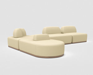 The Magna Preconfigured Sectional is a beige modular sofa set on a light gray background. It includes three rounded-edged sections with low wooden bases, cushioned seats, and a middle section with a backrest facing opposite directions.