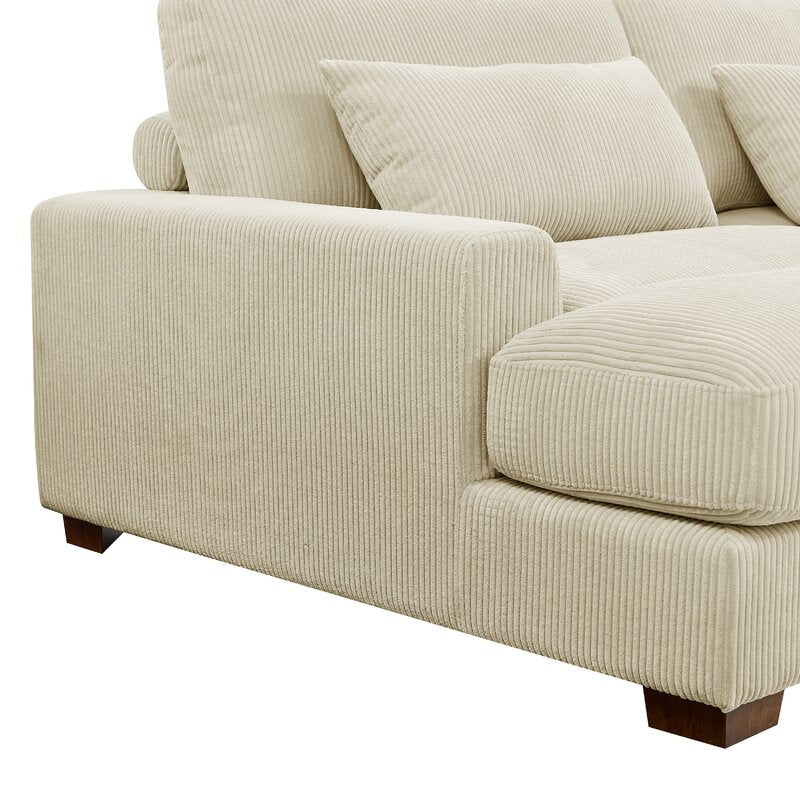 The Etta Avenue Mordecai 90'' Square Arm Sofa features a beige corduroy design, complete with plush cushions and low, dark wooden legs. The ribbed fabric texture enhances its soft and cozy appearance.