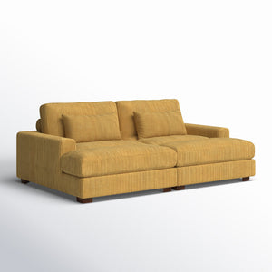 The Etta Avenue Mordecai 90'' Square Arm Sofa is a mustard yellow corduroy piece featuring two large cushions and two smaller accent pillows, set against a white background. It showcases a modern design with a low profile and wide armrests.