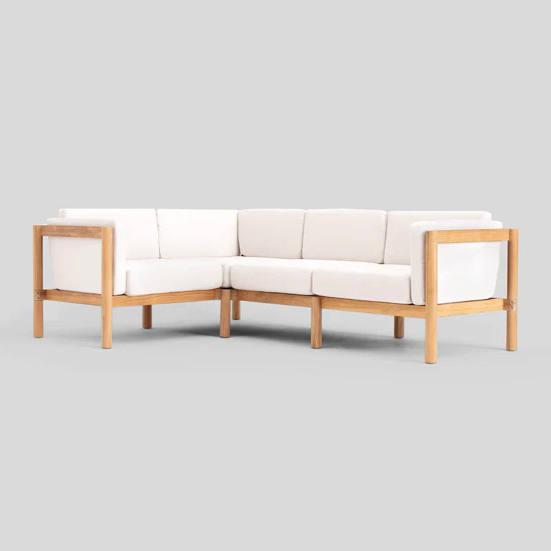 The Haven Sectional is a cream-colored L-shaped sofa with a wooden frame set against a plain gray background. It features cushions for both seating and back support, designed in a minimalist style.