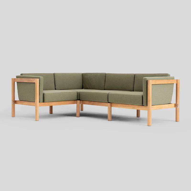 The Haven Sectional is a modern L-shaped sofa featuring olive green cushions and a wooden frame, set against a plain gray background.