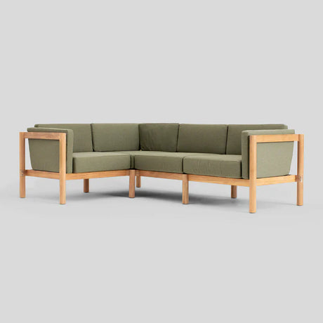 The Haven Sectional is a modern L-shaped sofa featuring olive green cushions and a wooden frame, set against a plain gray background.