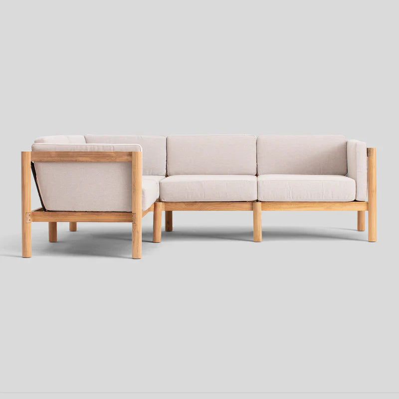 Introducing the Haven Sectional: a beige cushioned sectional sofa with a natural wood frame set against a light gray background. It boasts a minimalist, modern design characterized by clean lines and offers ample seating space.