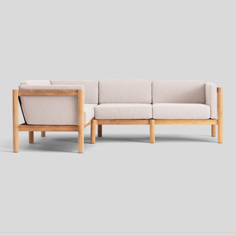 Introducing the Haven Sectional: a beige cushioned sectional sofa with a natural wood frame set against a light gray background. It boasts a minimalist, modern design characterized by clean lines and offers ample seating space.
