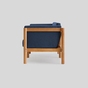 Side view of the Haven Sofa, a modern piece in blue with a wooden frame, set against a light gray background. The design showcases clean lines and a minimalist aesthetic.