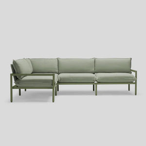 Introducing the Terra Sectional: a minimalist green sofa with a metal frame, featuring cushioned seats and backrests, elegantly displayed against a plain gray background.