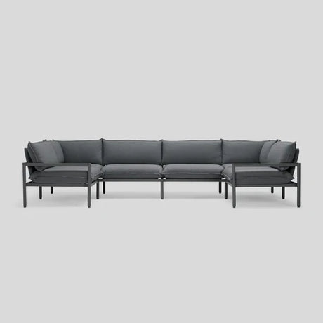 The Terra Sectional, characterized by its modern and minimalist design with a dark gray hue, metal frame, and cushions, is showcased against a plain light gray background.